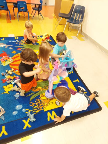 Children playing with toys on a colorful rug