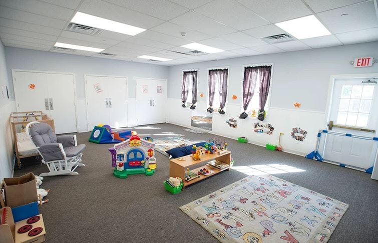 Playroom with toys, crib, and rocking chair