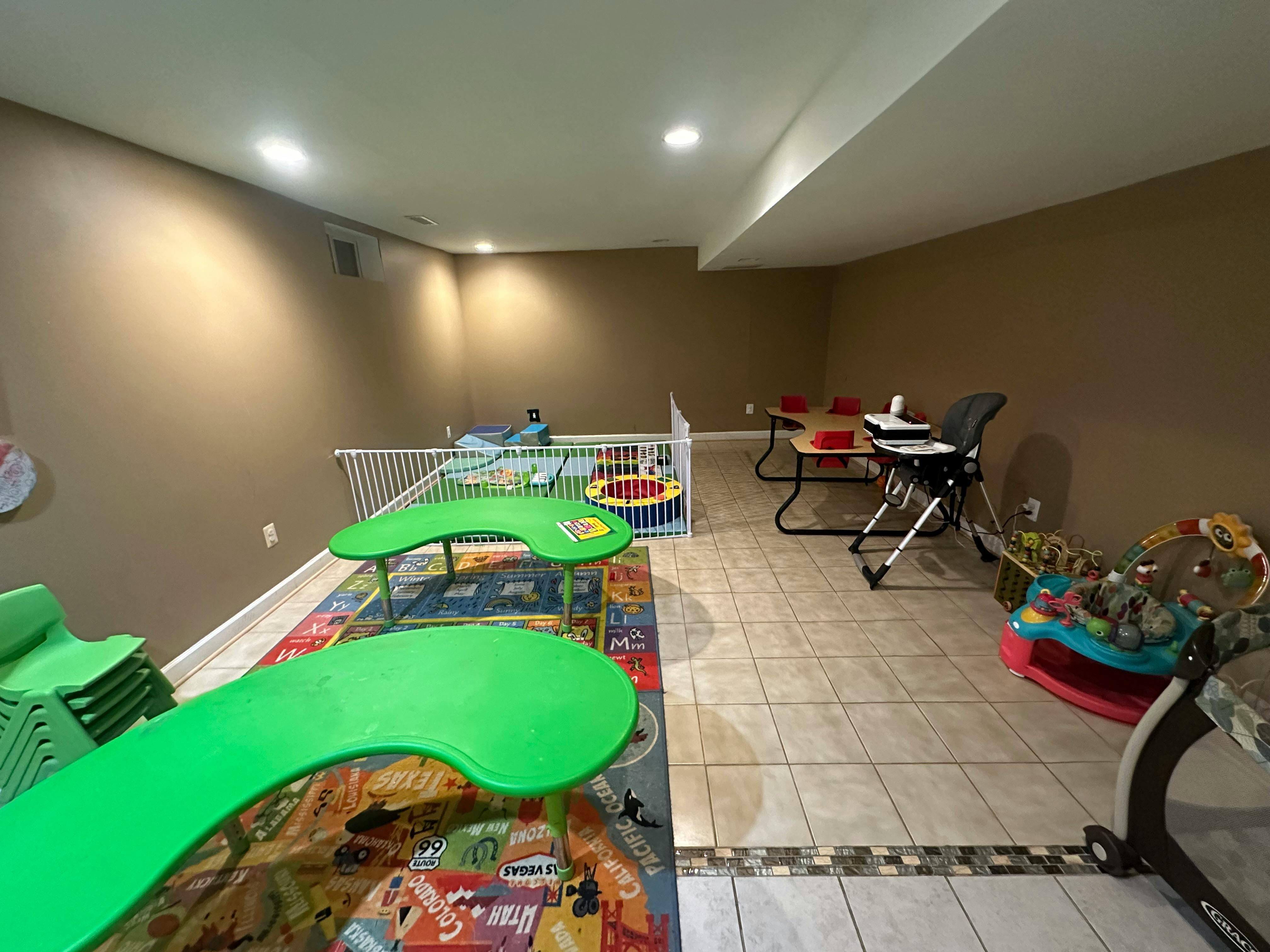 Playroom with green tables, playpen, and high chair