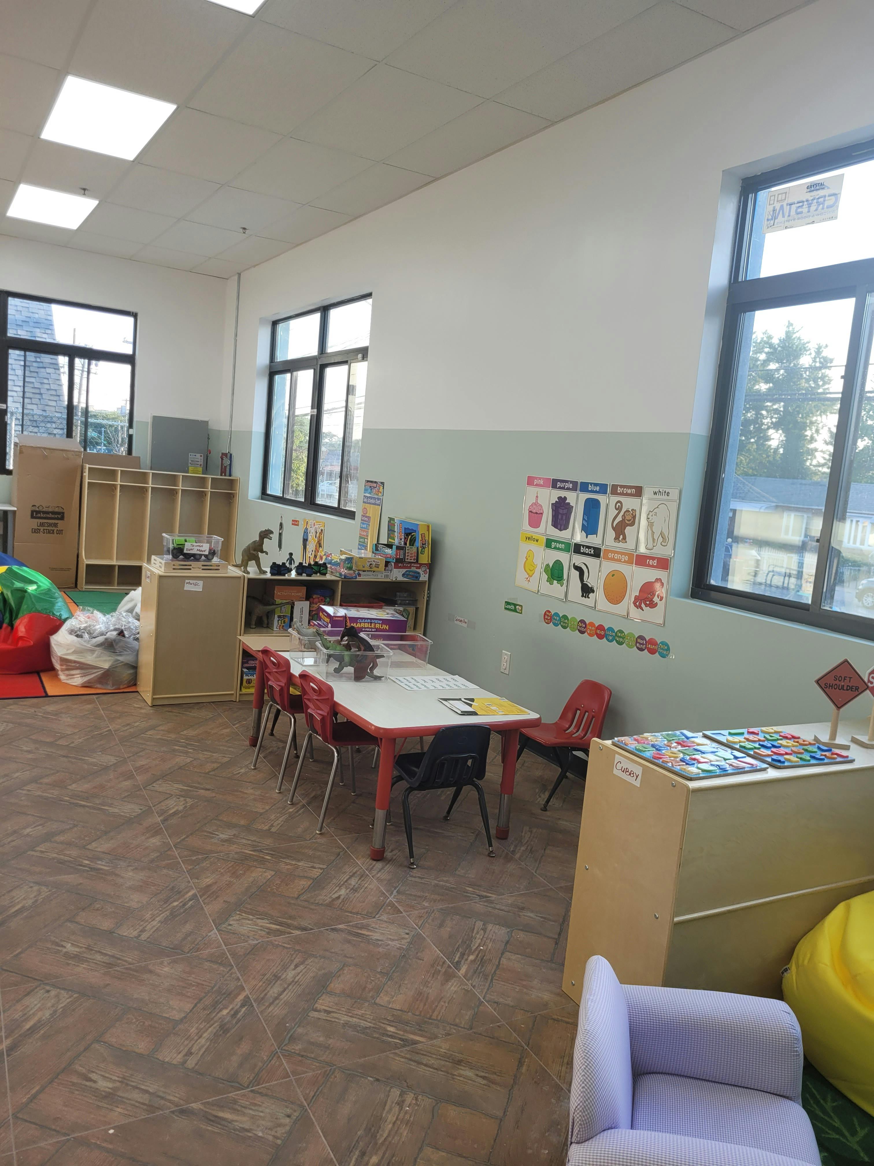 Classroom with small tables and chairs, storage units, and windows