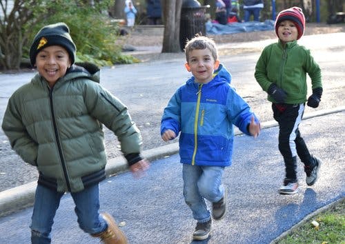 Three children running outdoors