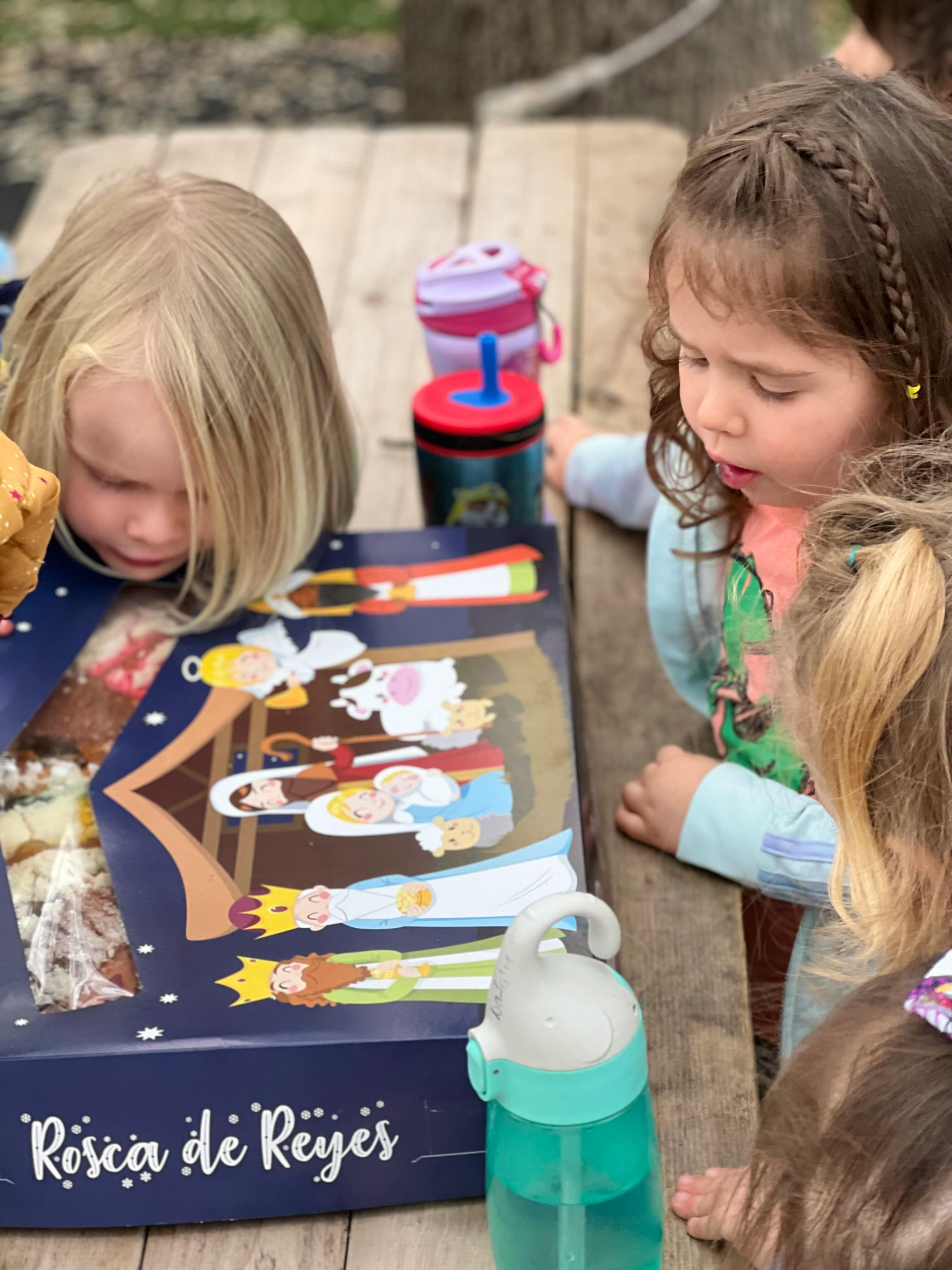 Children looking at a box of Rosca de Reyes