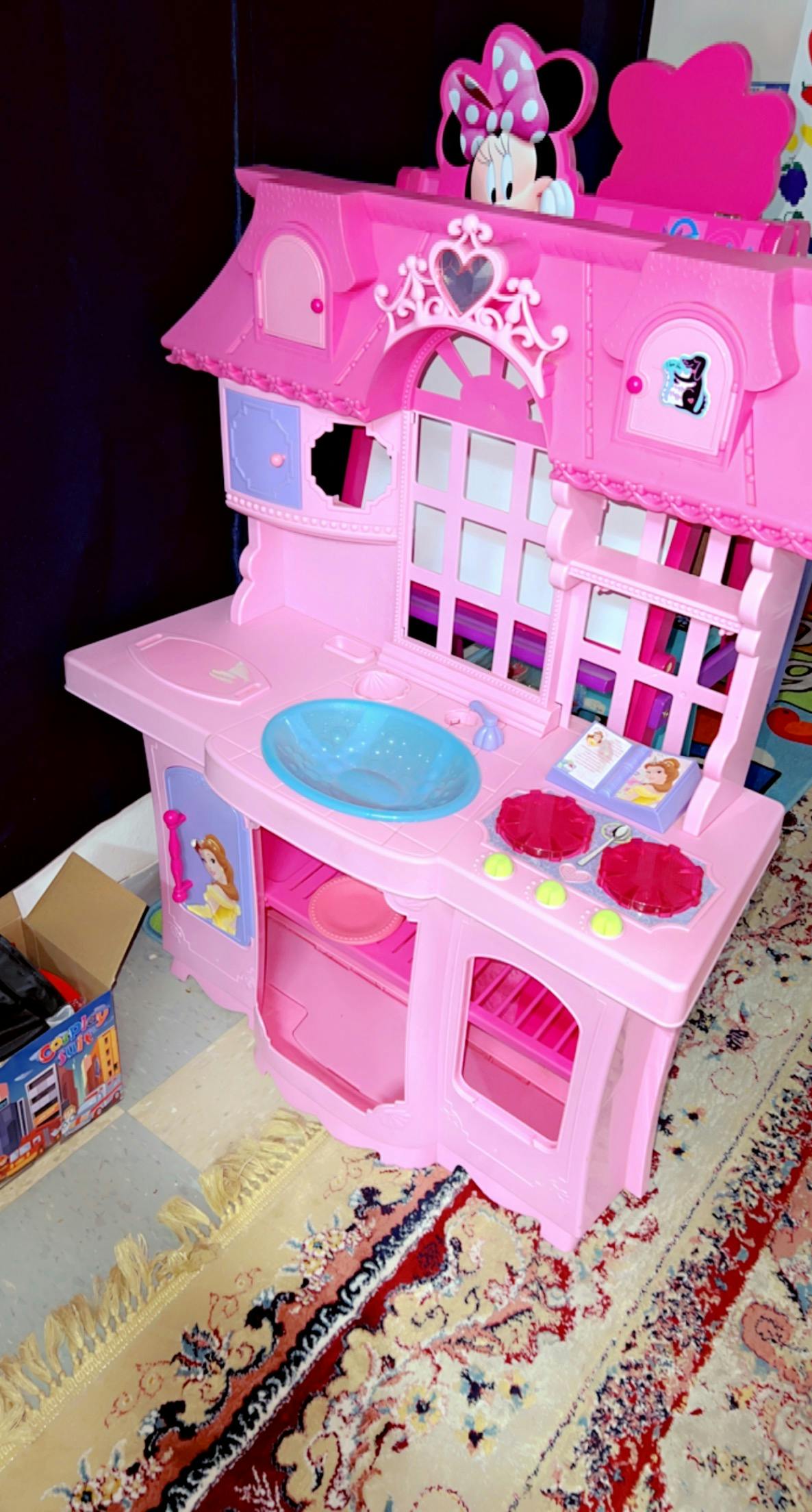 Pink toy kitchen with a blue sink and Minnie Mouse figure on top