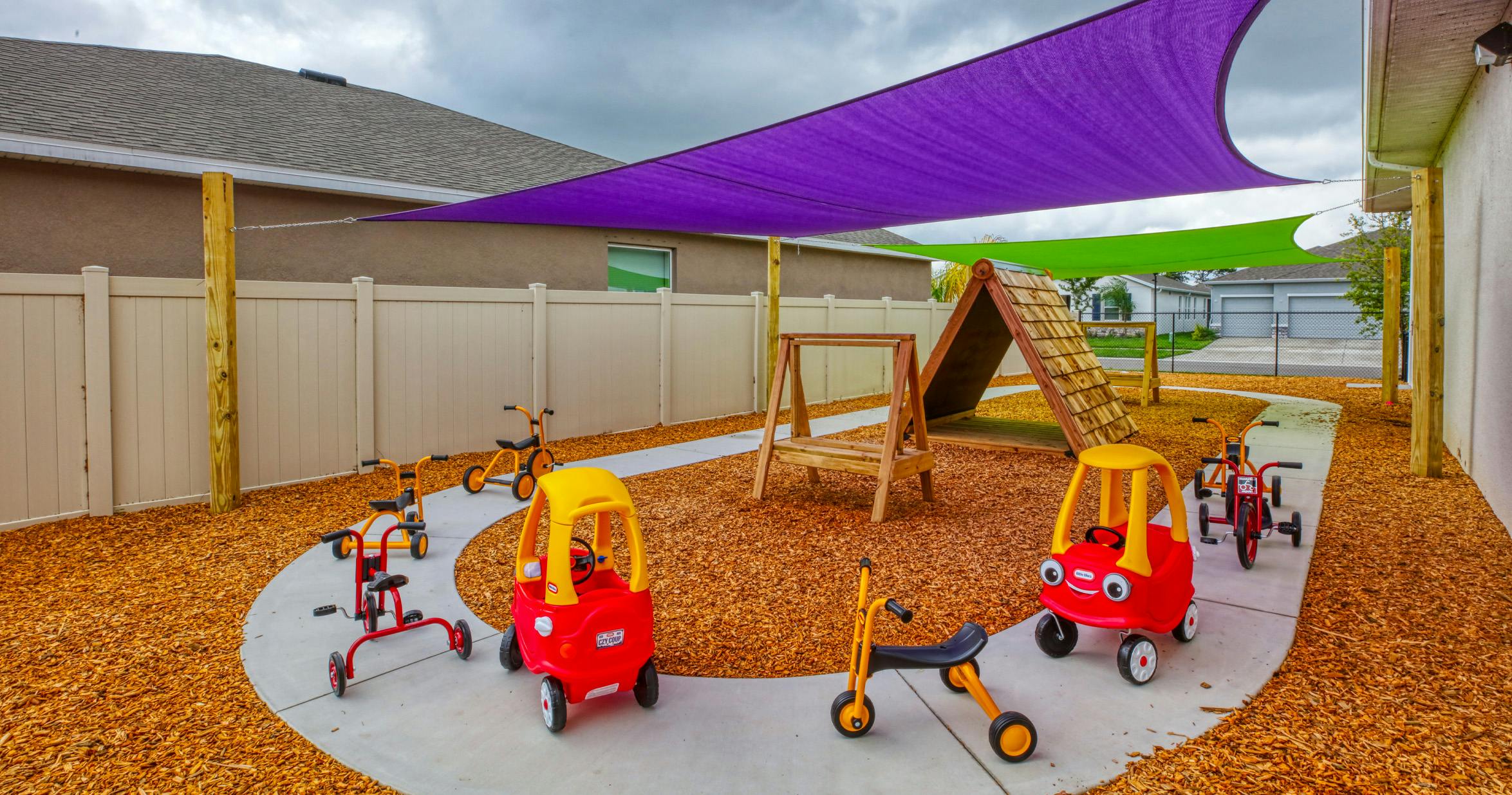 Outdoor playground with various tricycles and play equipment