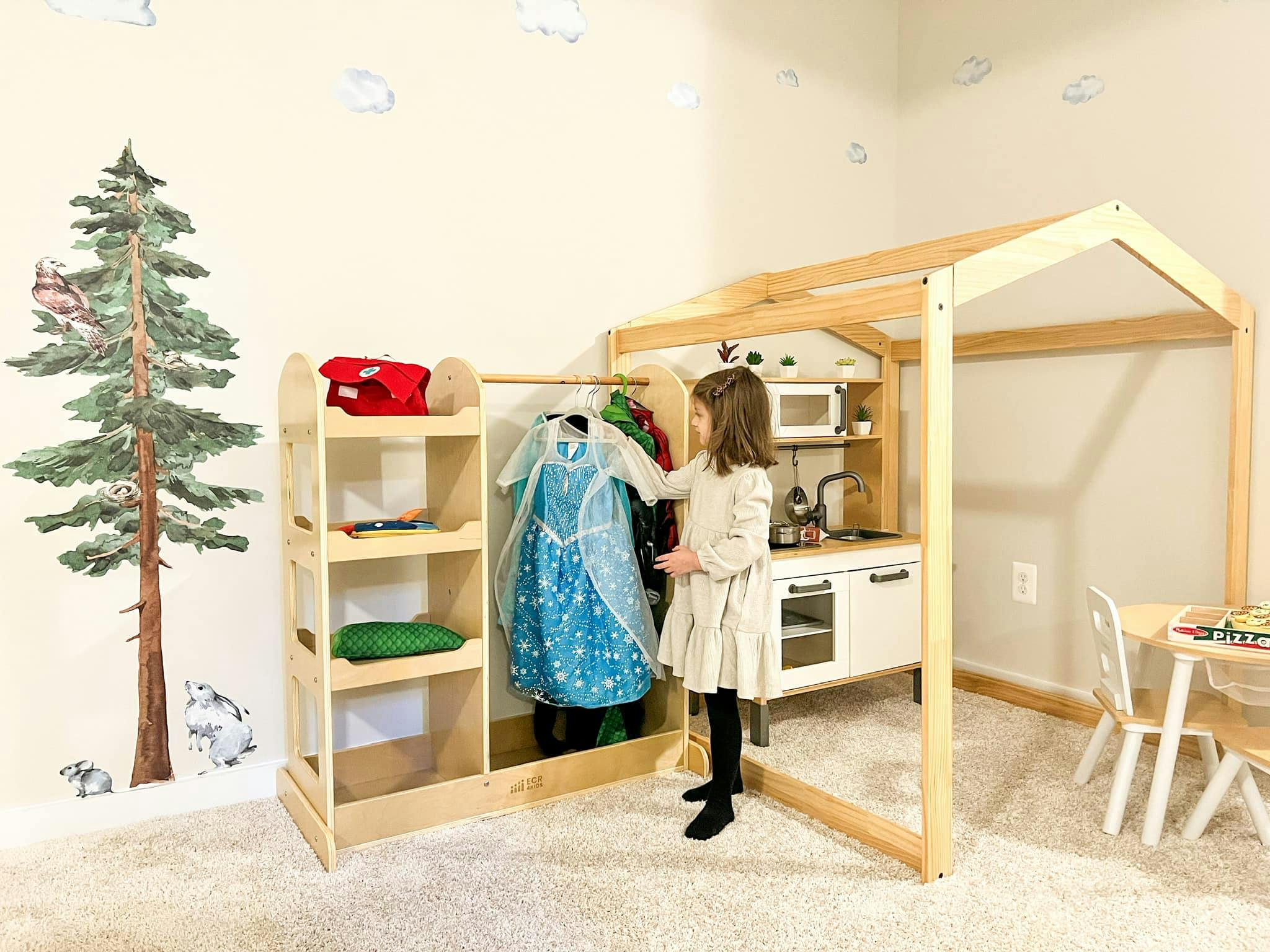 Child looking at costumes on a clothing rack in a play area