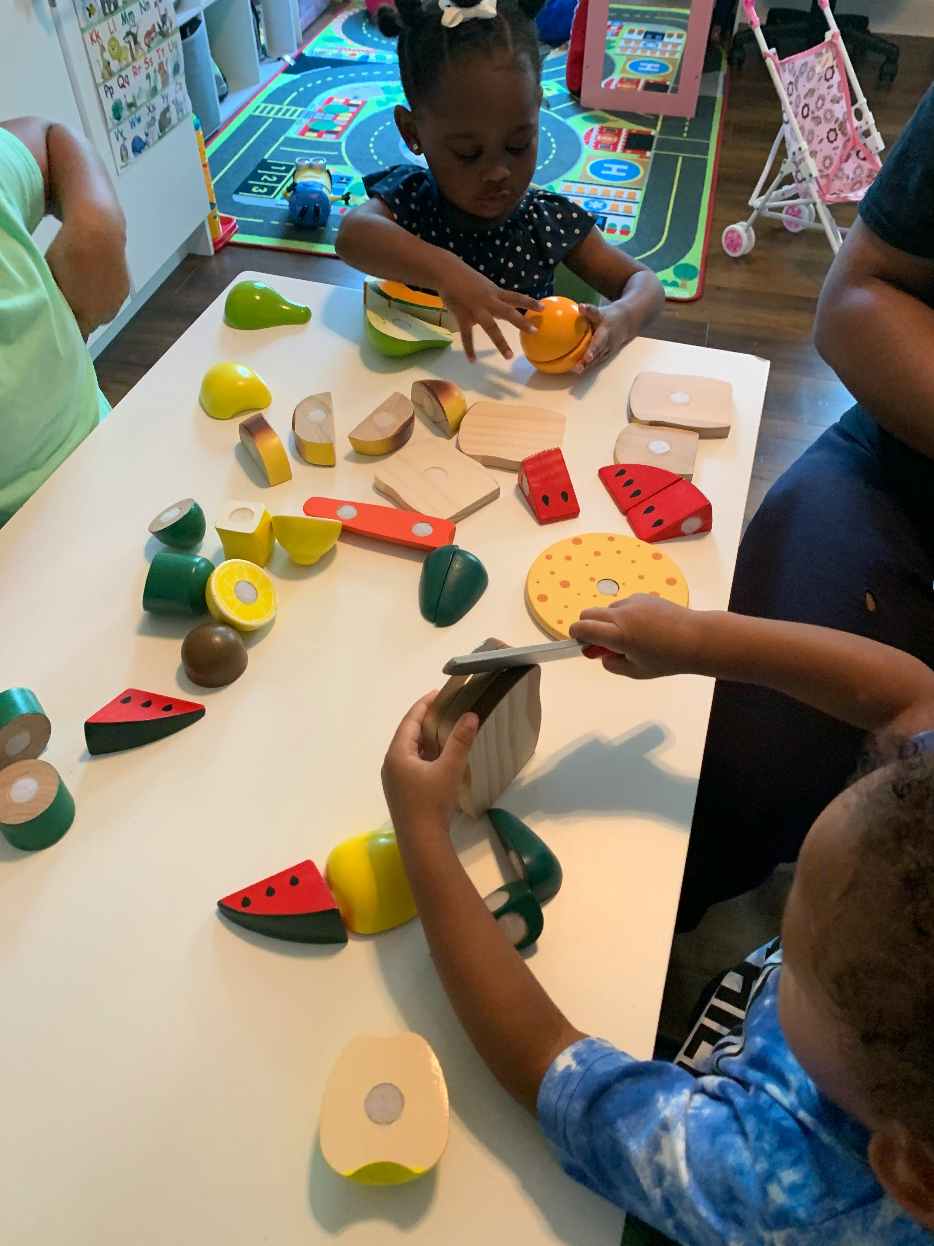 Children playing with toy food on a table