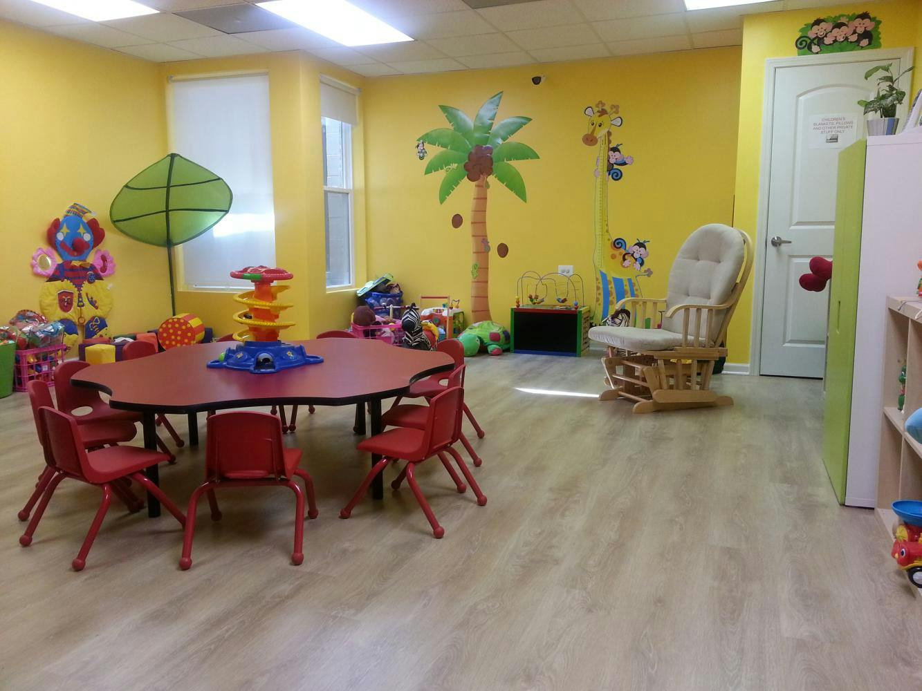 Playroom with small red table and chairs, toys, and a rocking chair