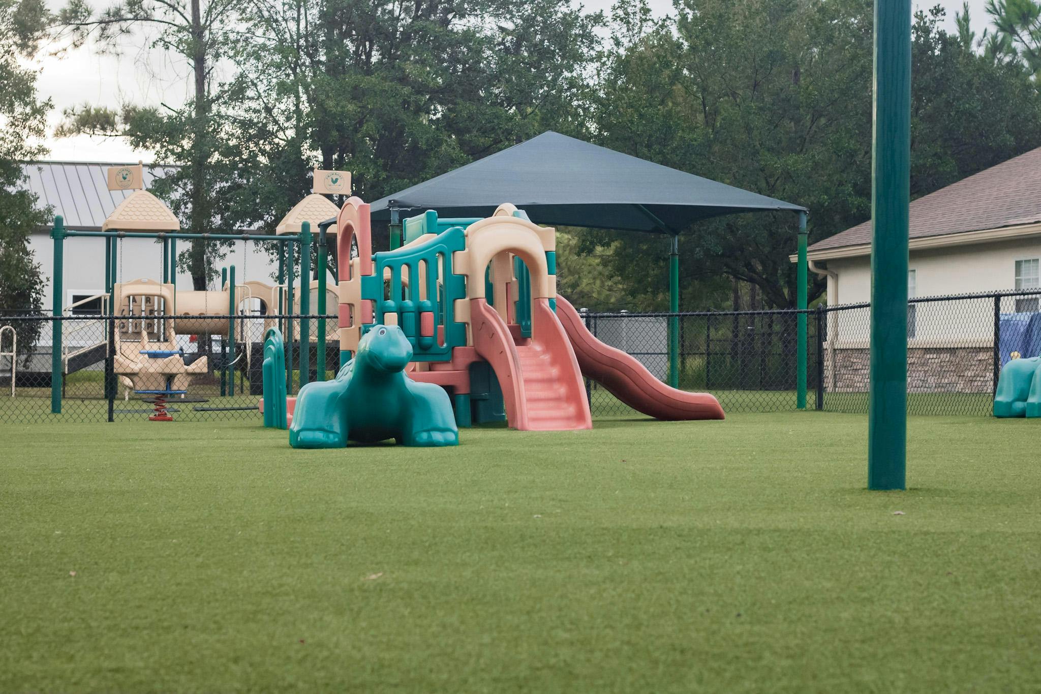 Playground with slides, climbing structures, and a shade canopy