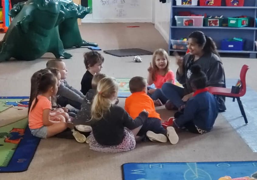 Adult and children sitting in a circle on the floor