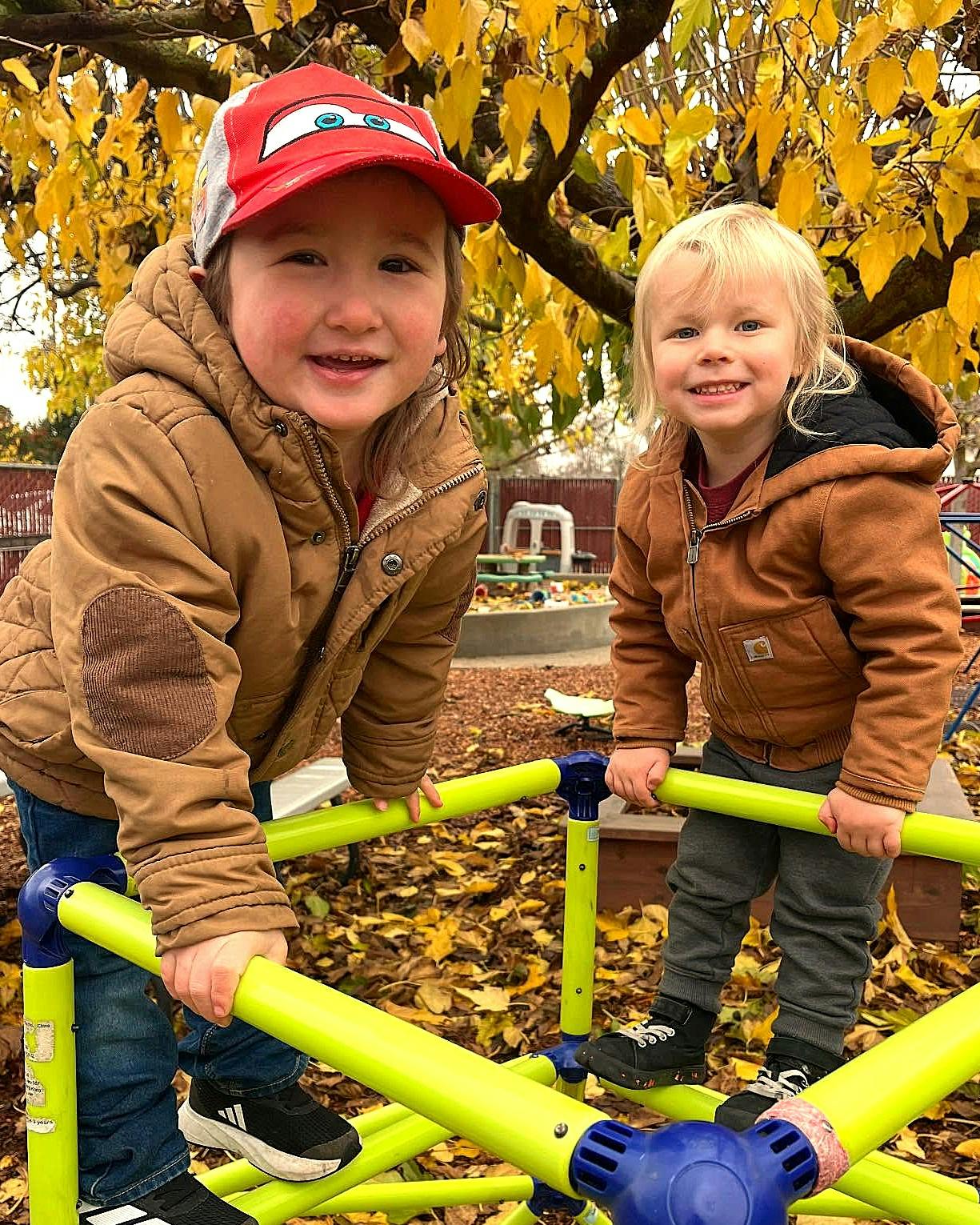 Two children on a playground climbing structure