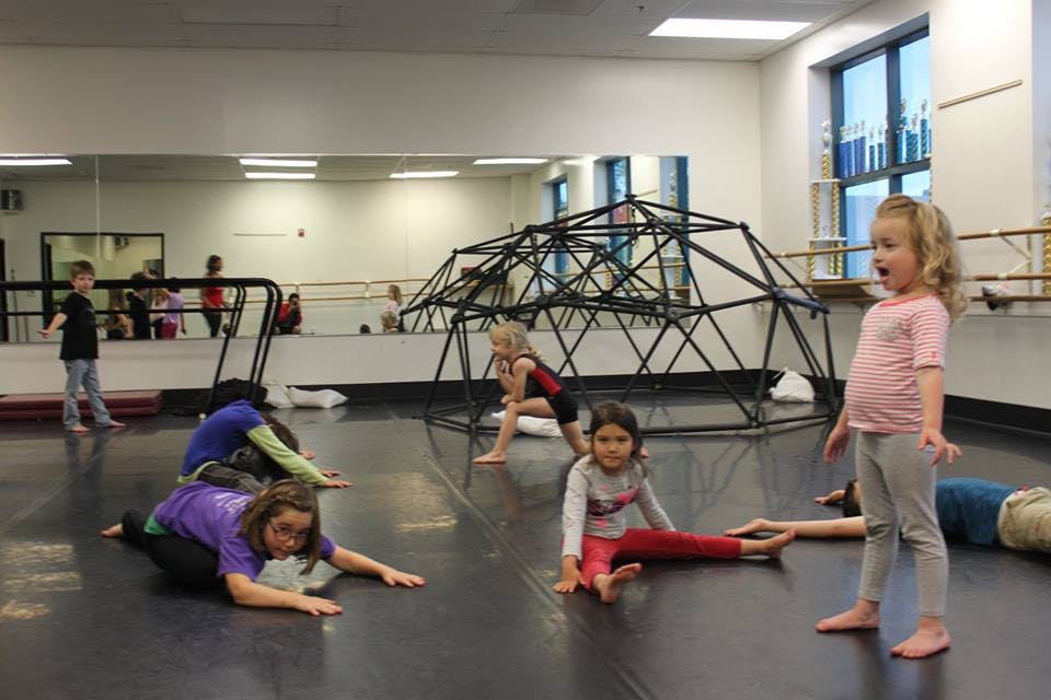 Children on the floor in a room with a climbing dome