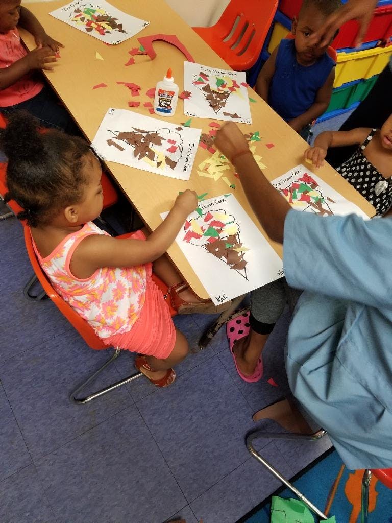 Children making ice cream cone crafts at a table