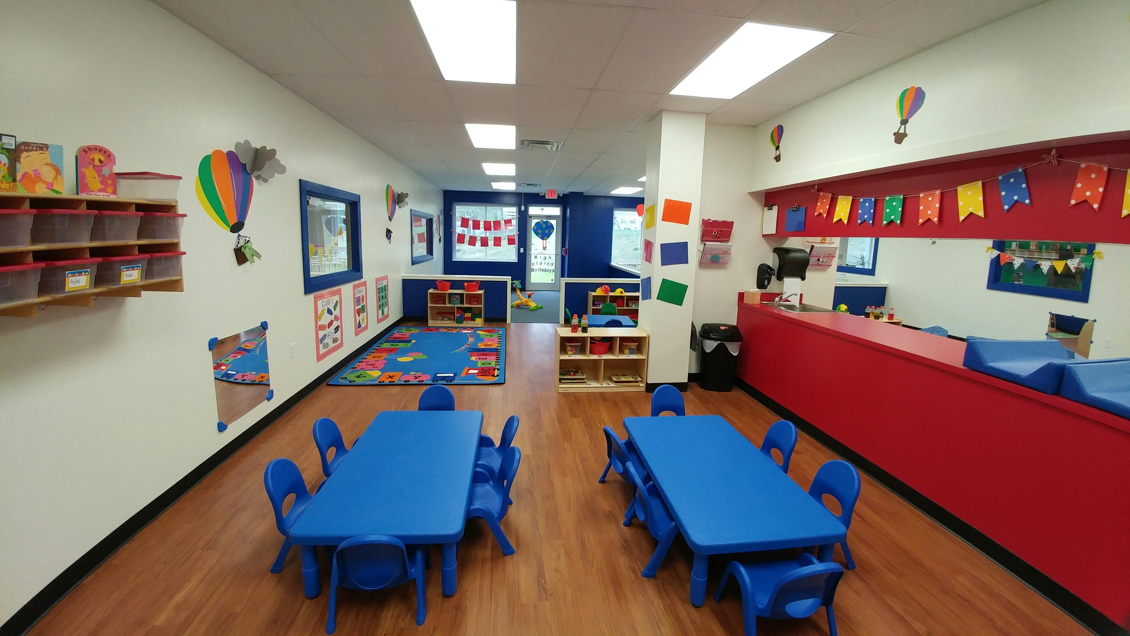Classroom with blue tables and chairs, colorful decorations