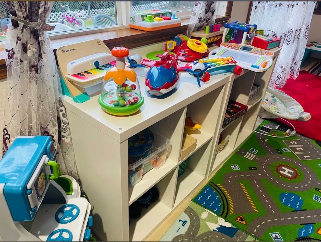 children's toys on a white shelf next to a window