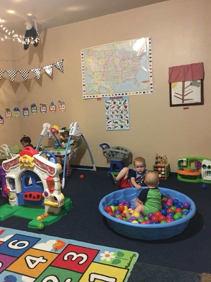 Children playing in a room with toys and a ball pit