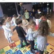 Children holding hands in a circle on a colorful rug