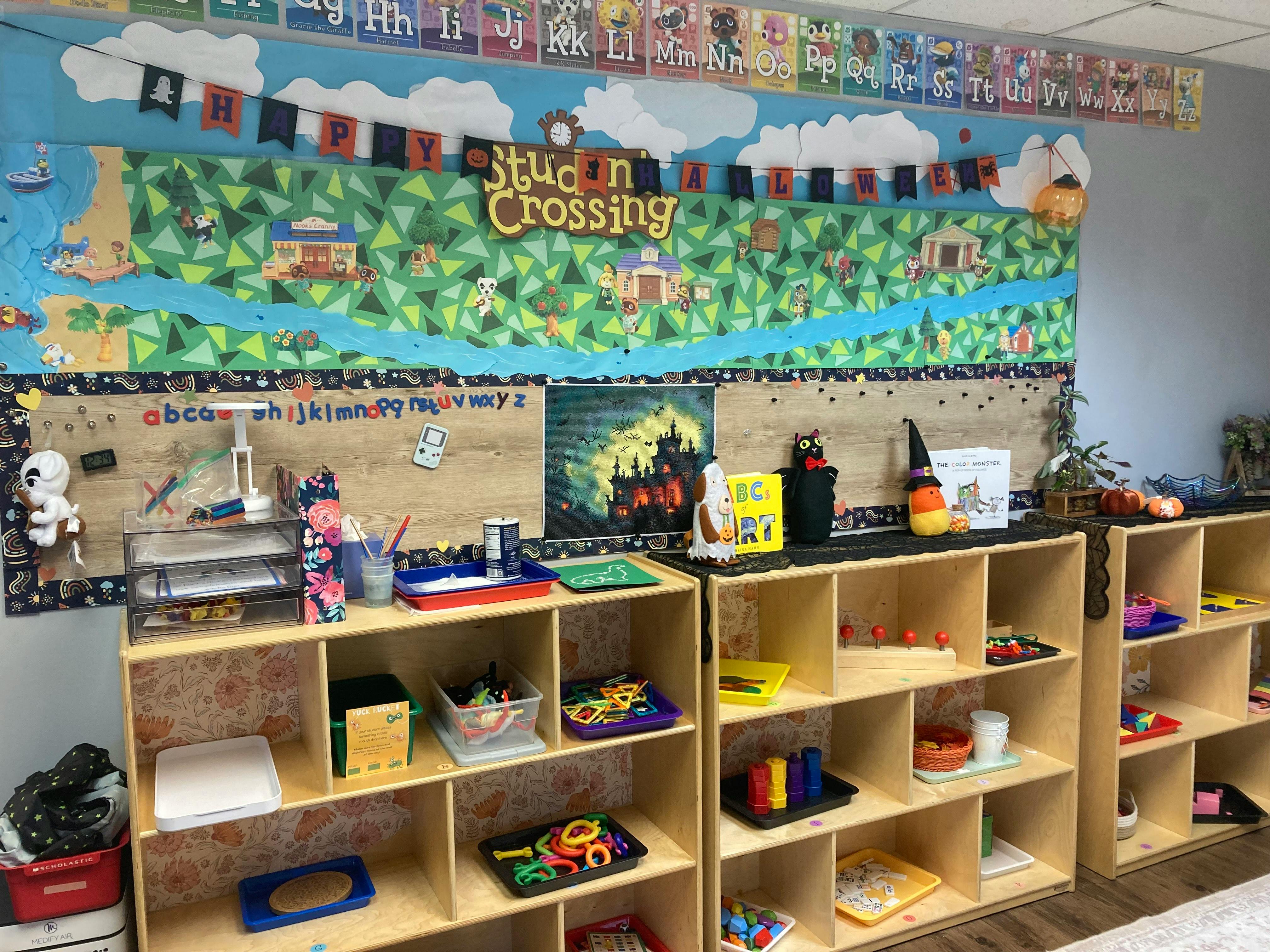 Classroom with shelves of learning materials and a "Student Crossing" banner
