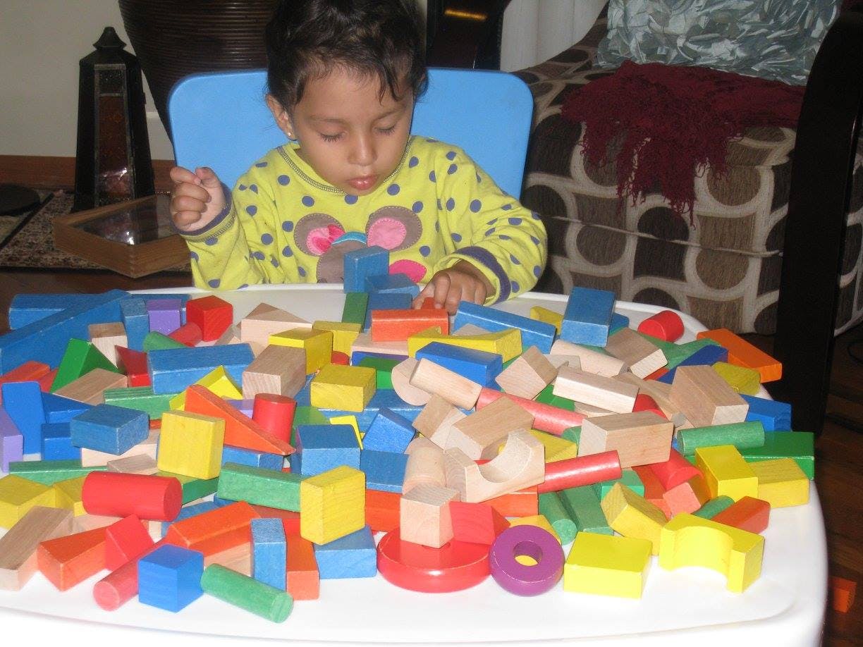 Child playing with colorful wooden blocks