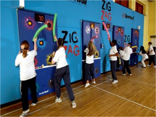 Children playing an interactive wall game with foam tubes