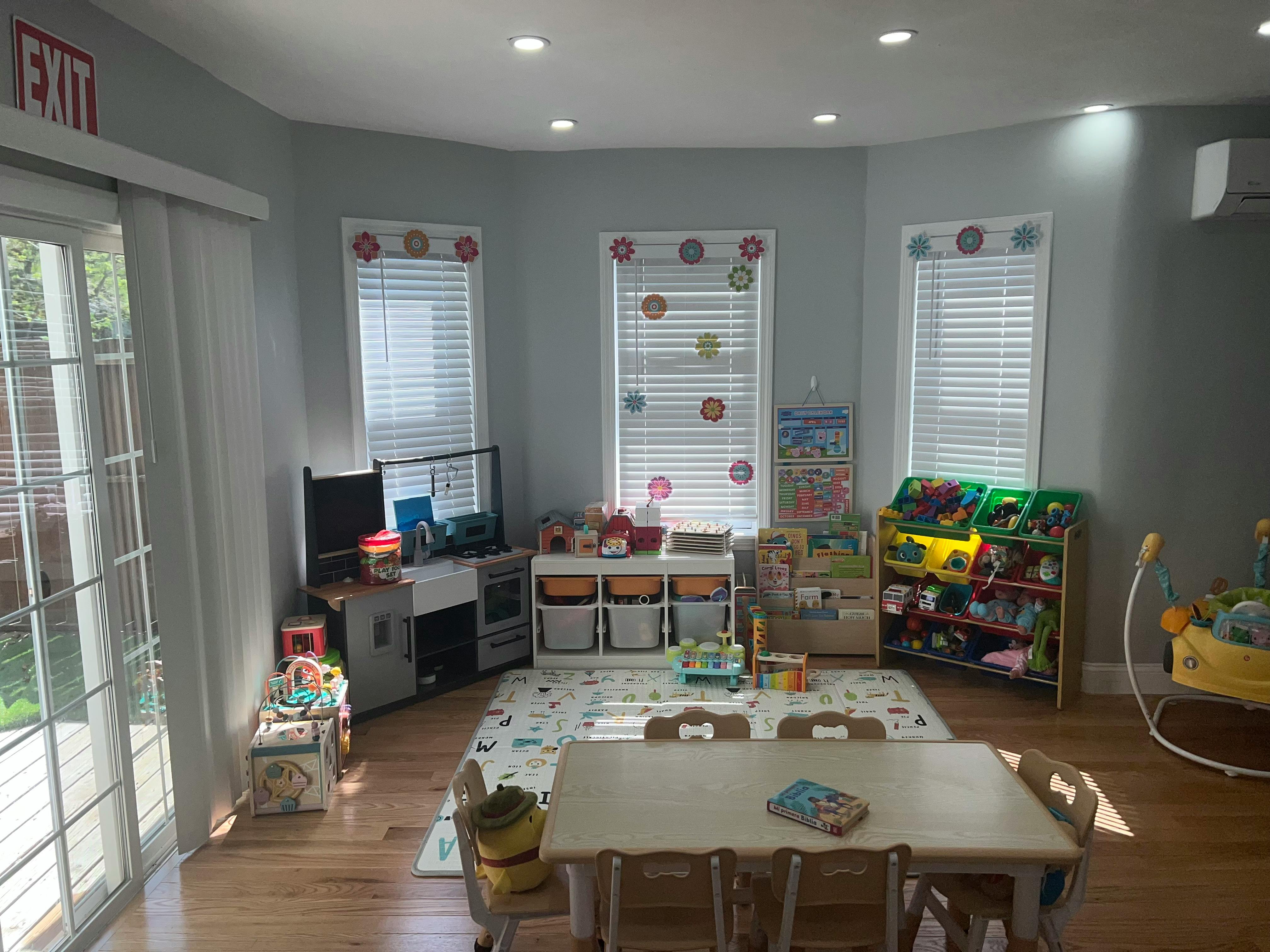 Playroom with toys, small table and chairs, and windows
