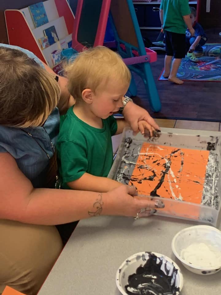 Adult and child painting together