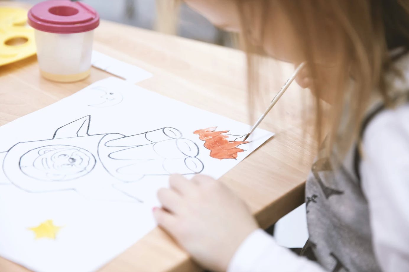 Child painting a drawing on paper