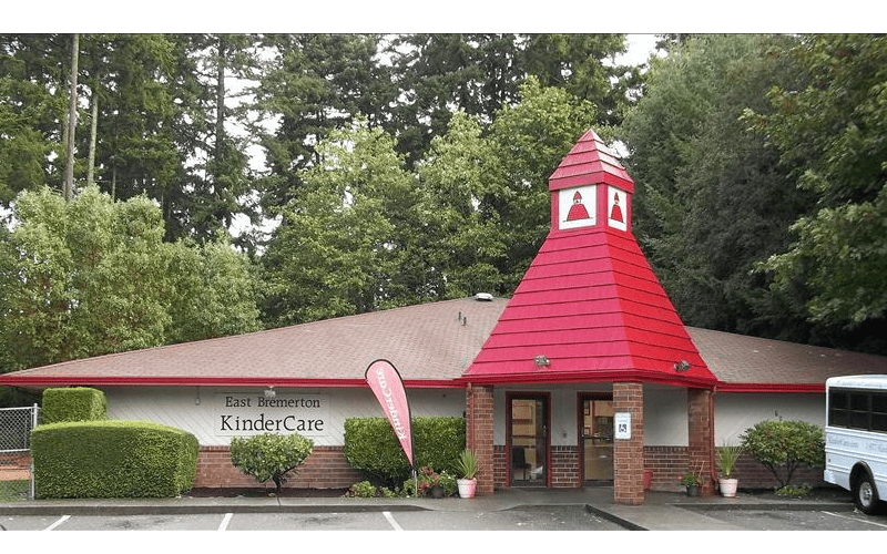 Building with a red roof and a prominent red turret with white trim, East Bremerton KinderCare text