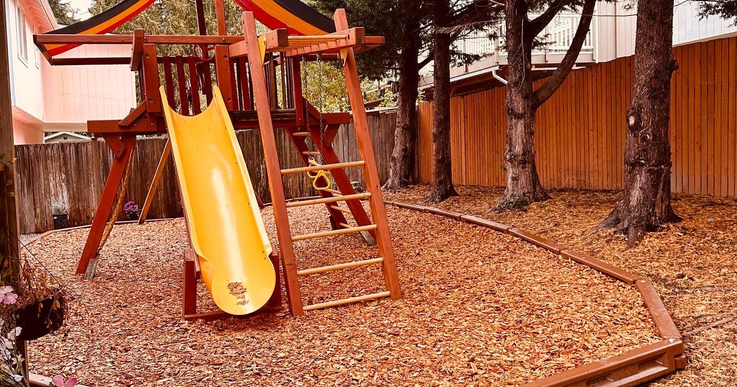 Wooden playground structure with a yellow slide