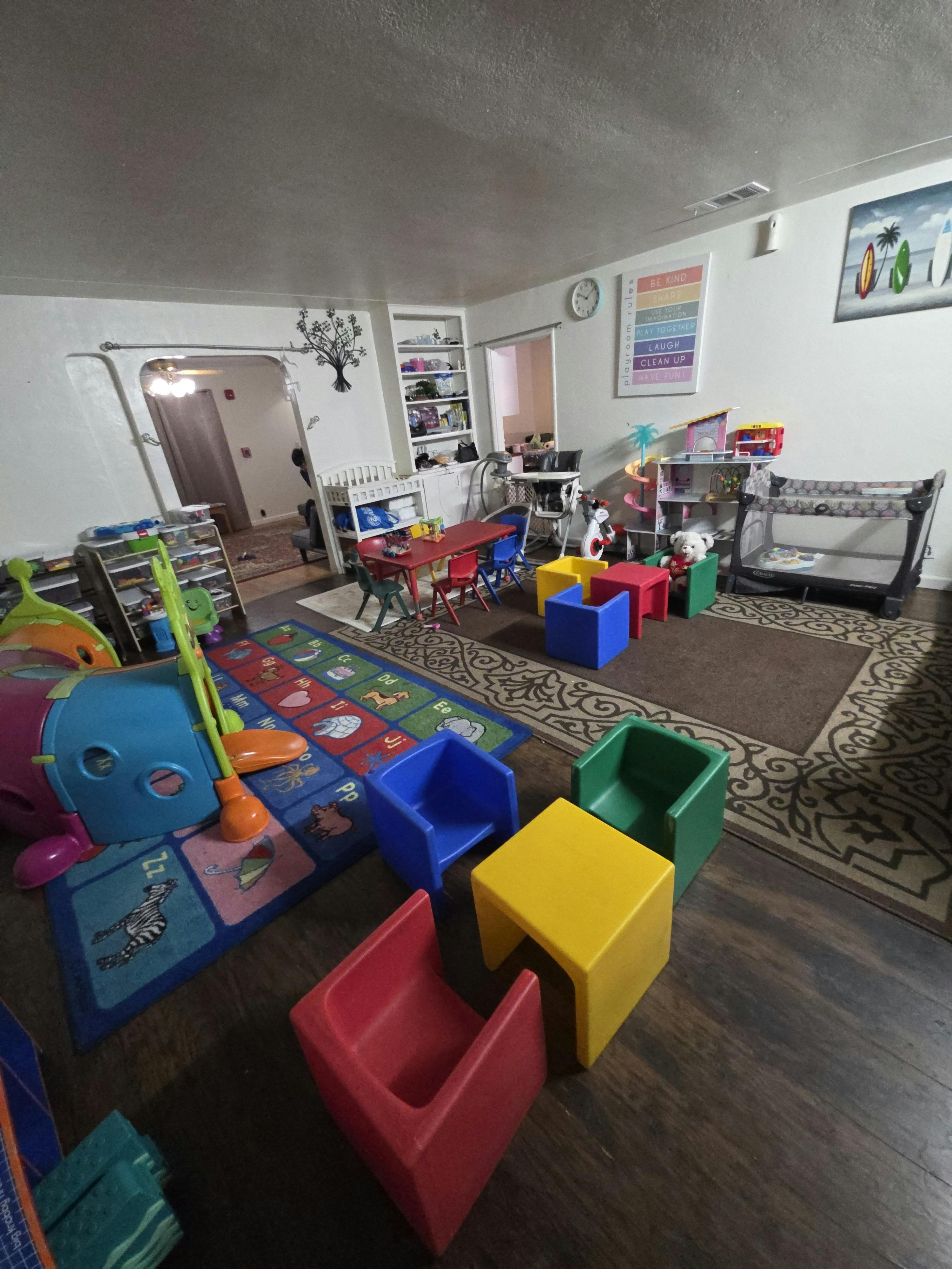 Children's playroom with colorful furniture, toys, and an alphabet rug