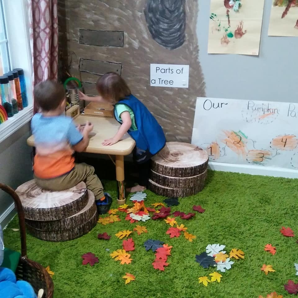 Two children playing at a small table in a classroom