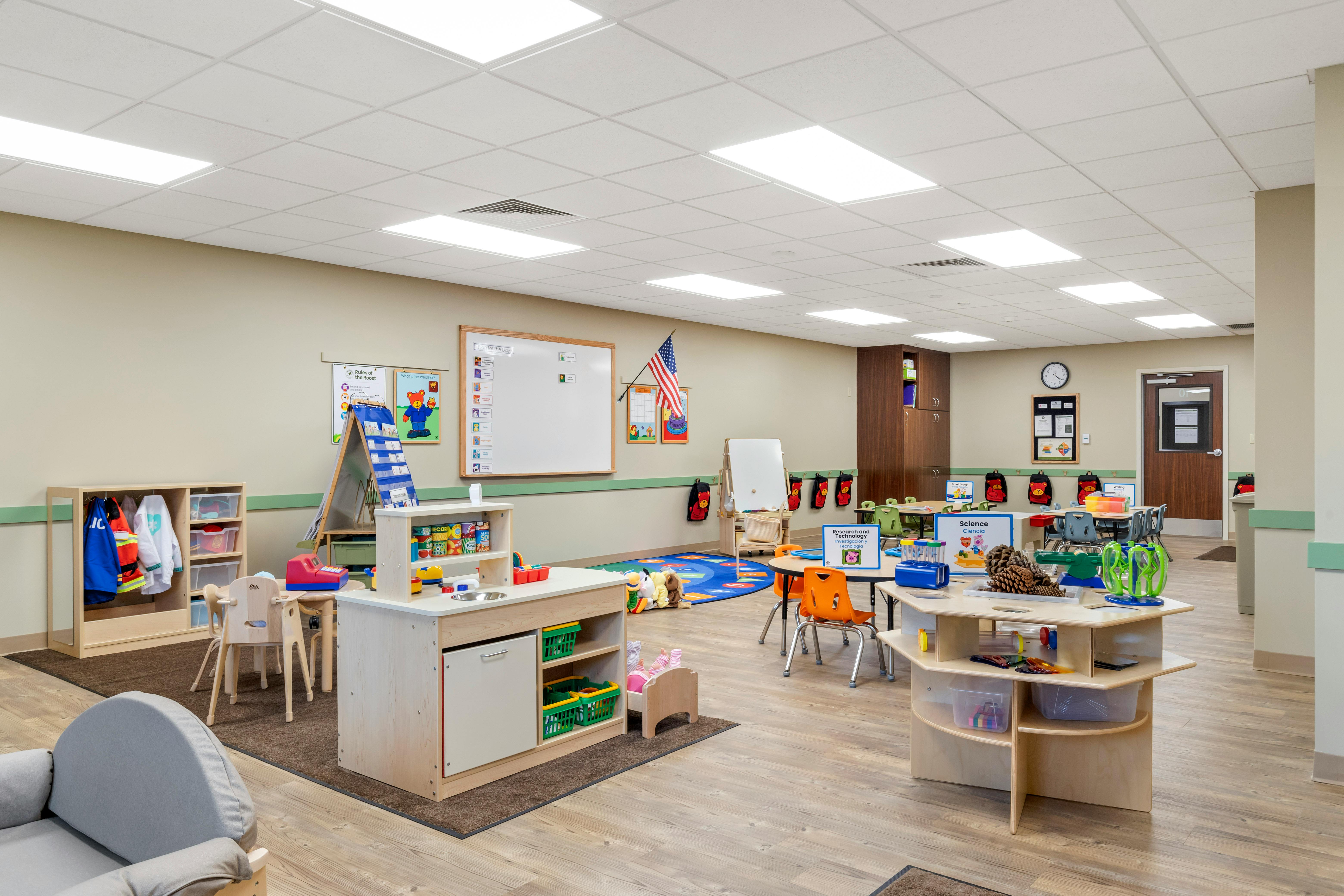 An empty classroom with multiple learning centers and small tables