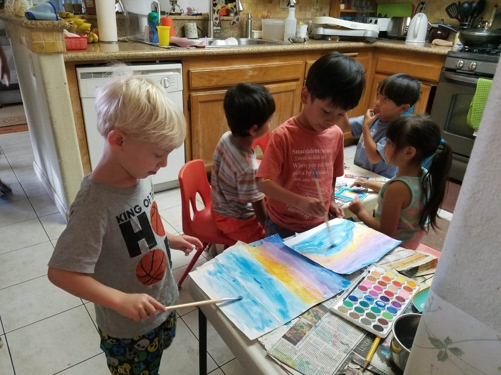 Children painting with watercolors at a table