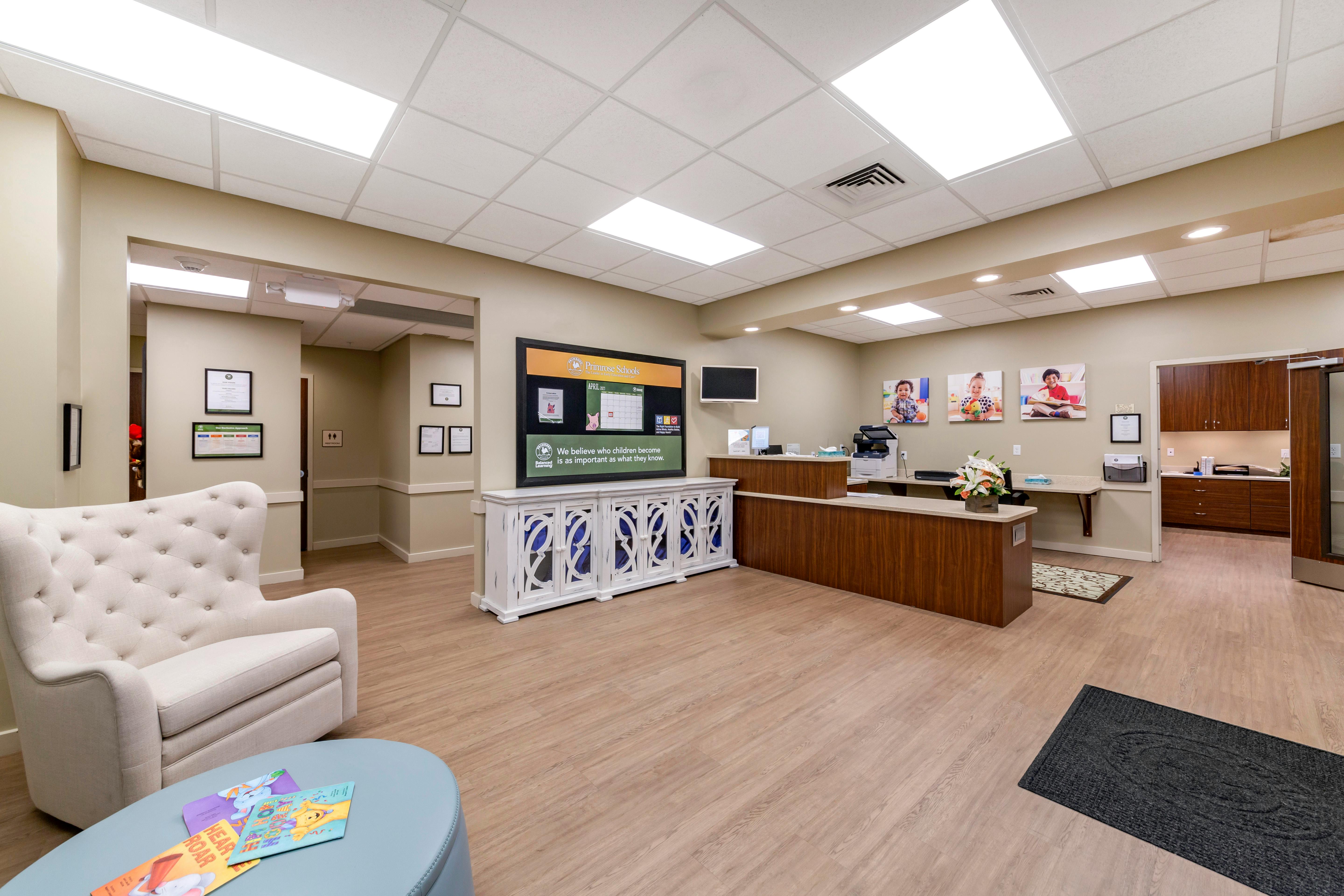 waiting area with a large bulletin board for Primrose Schools, reception desk