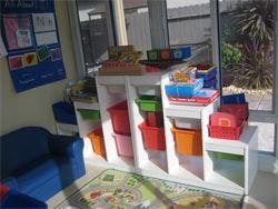 Storage shelves with colorful bins and toys in a room
