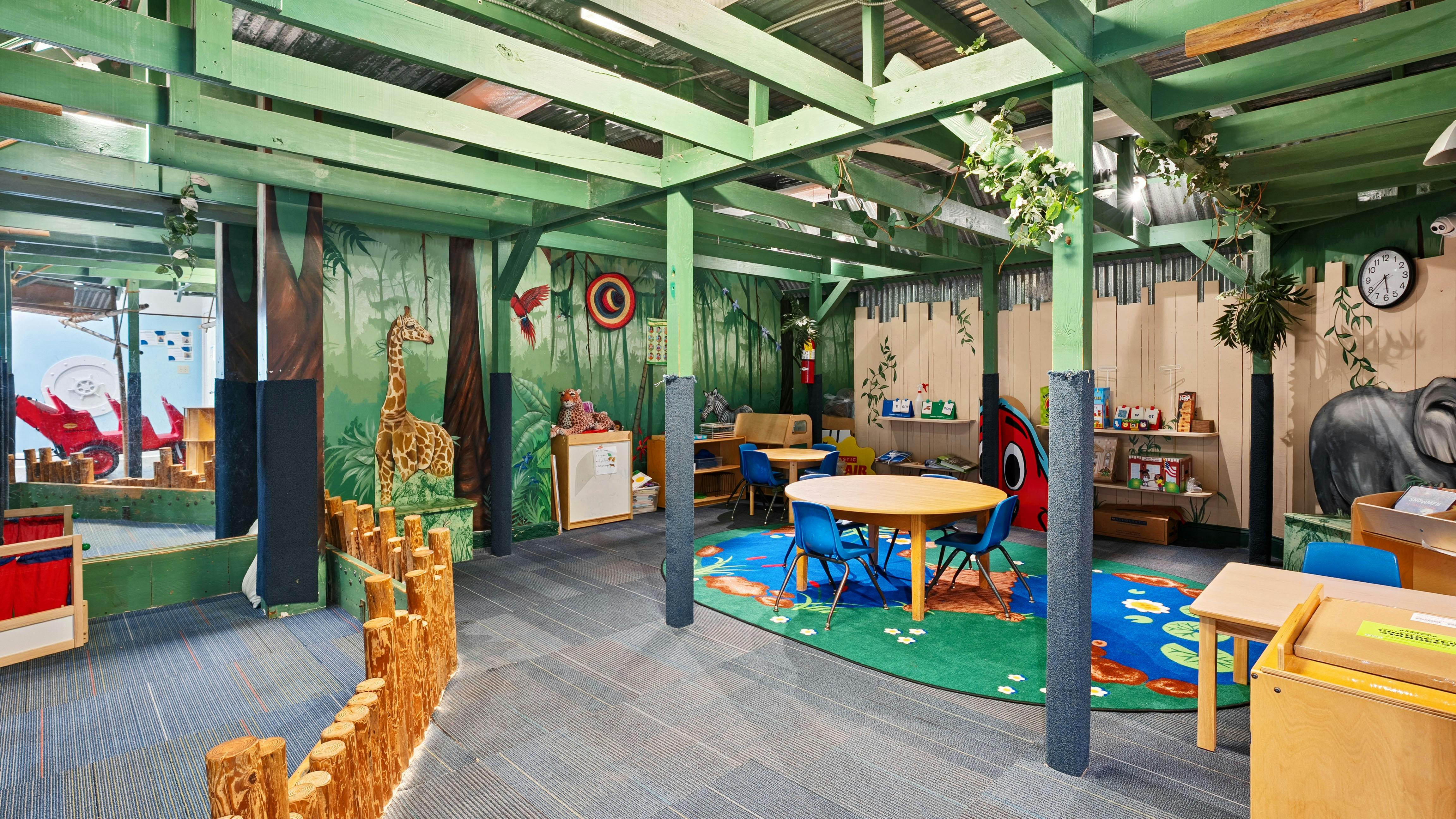 Children's play area with jungle-themed murals and furniture