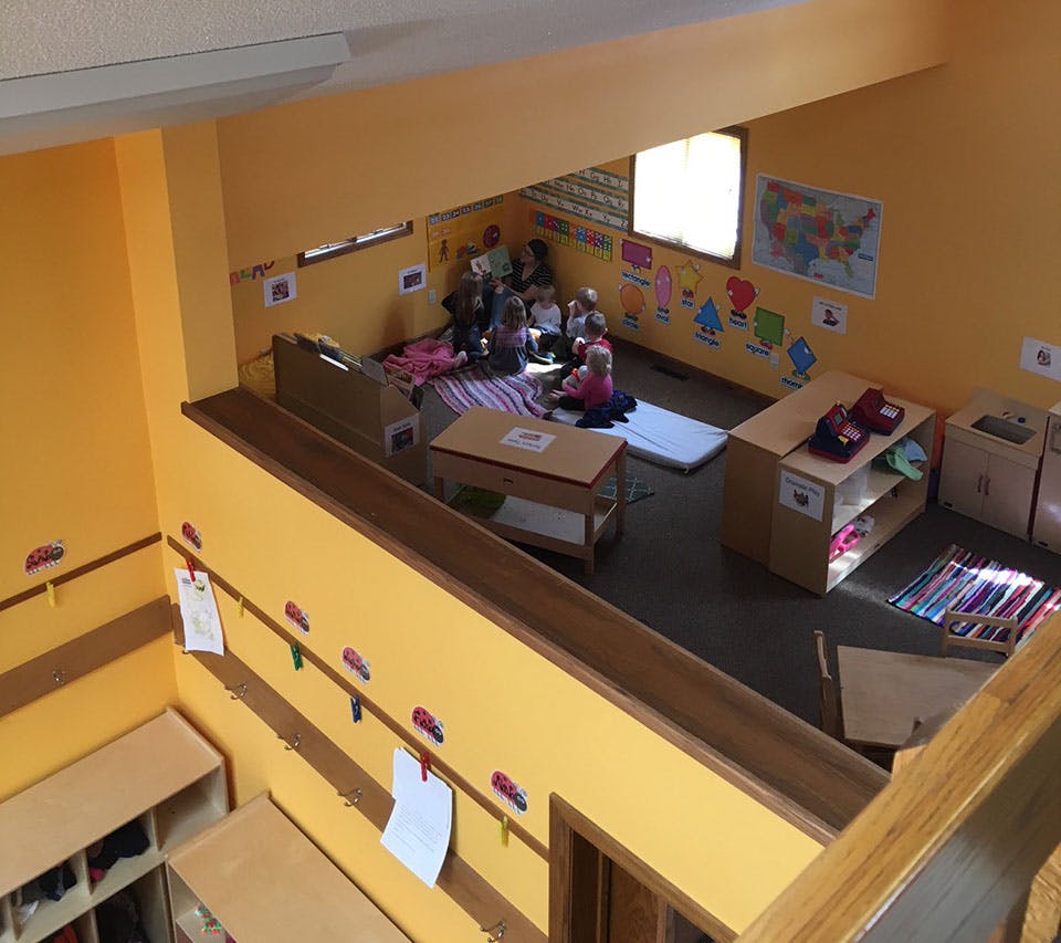 Children sitting on a rug in a classroom