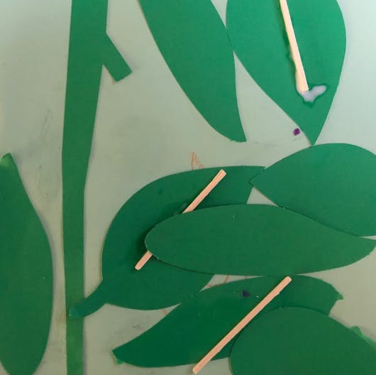 Green paper leaves with small wooden sticks