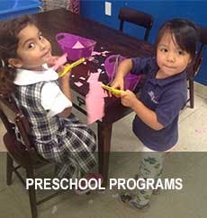 Two children cutting paper at a table