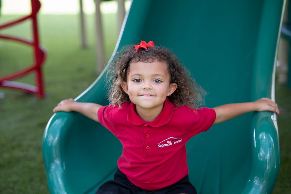 Child sitting on a green slide