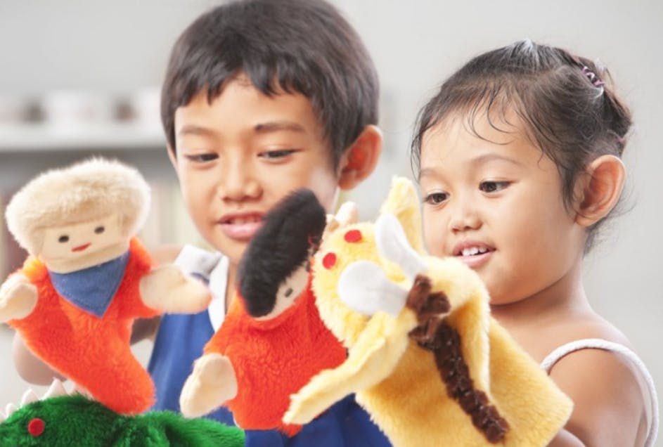 Two children playing with hand puppets