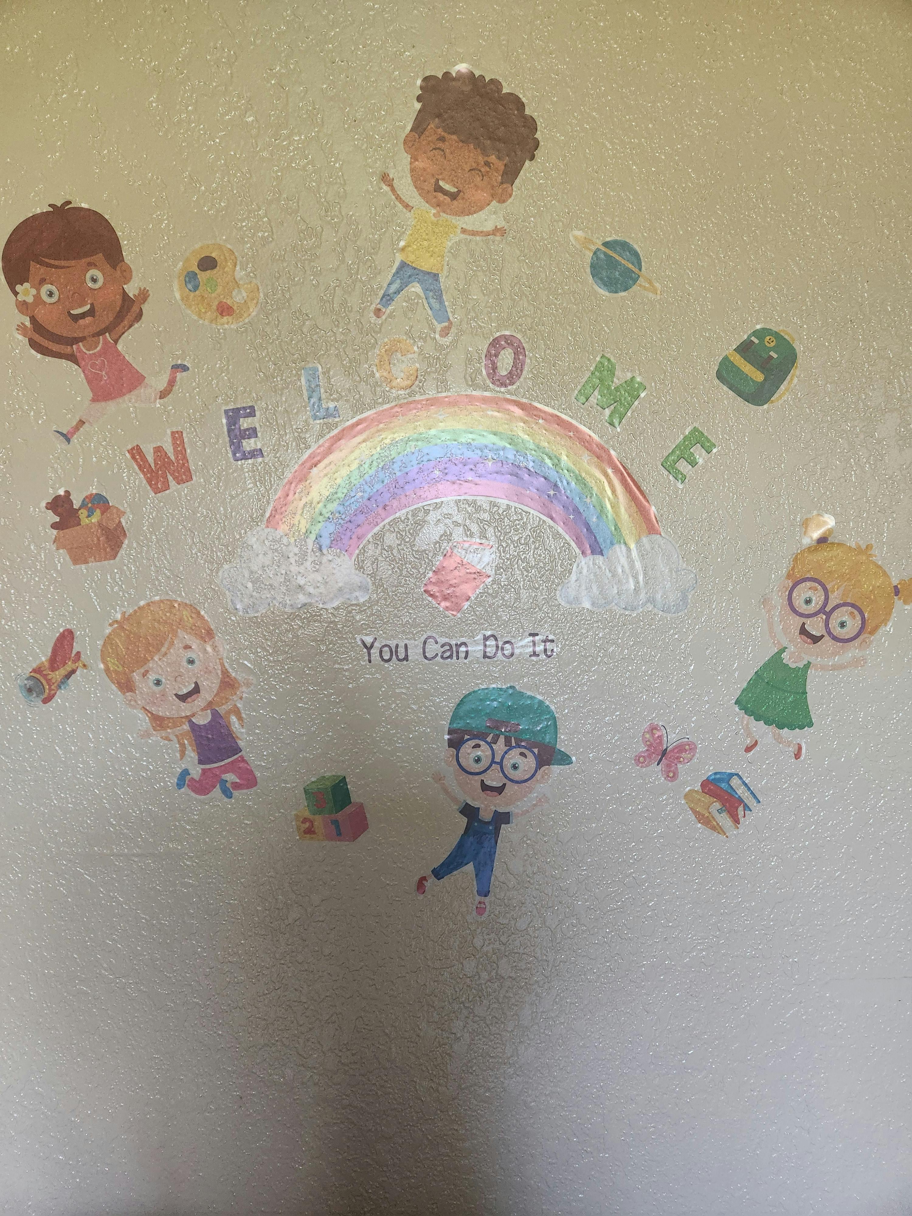 Children's wall decals of diverse children surrounding a rainbow with text "You Can Do It"