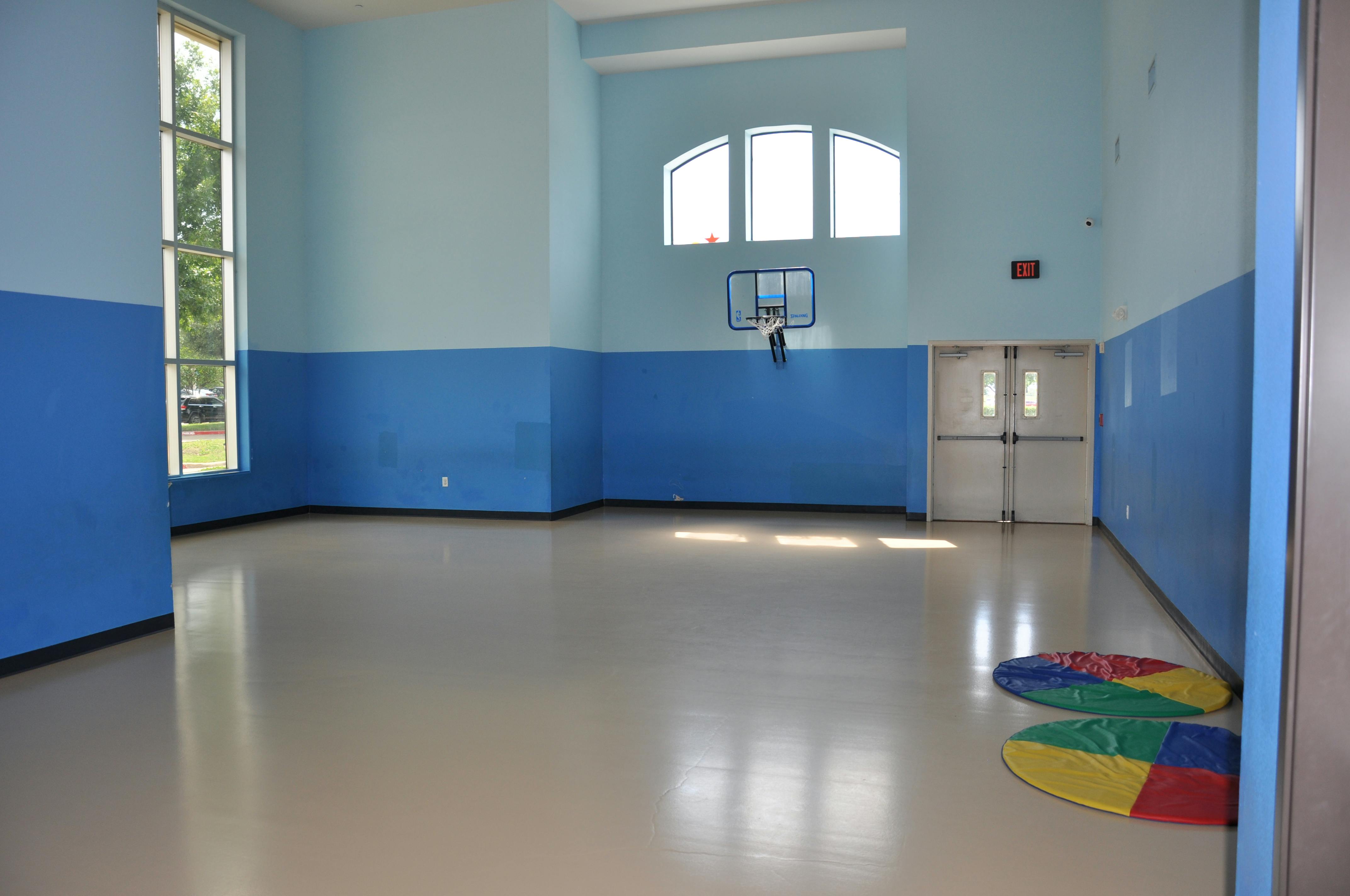 Empty indoor recreation room with a basketball hoop