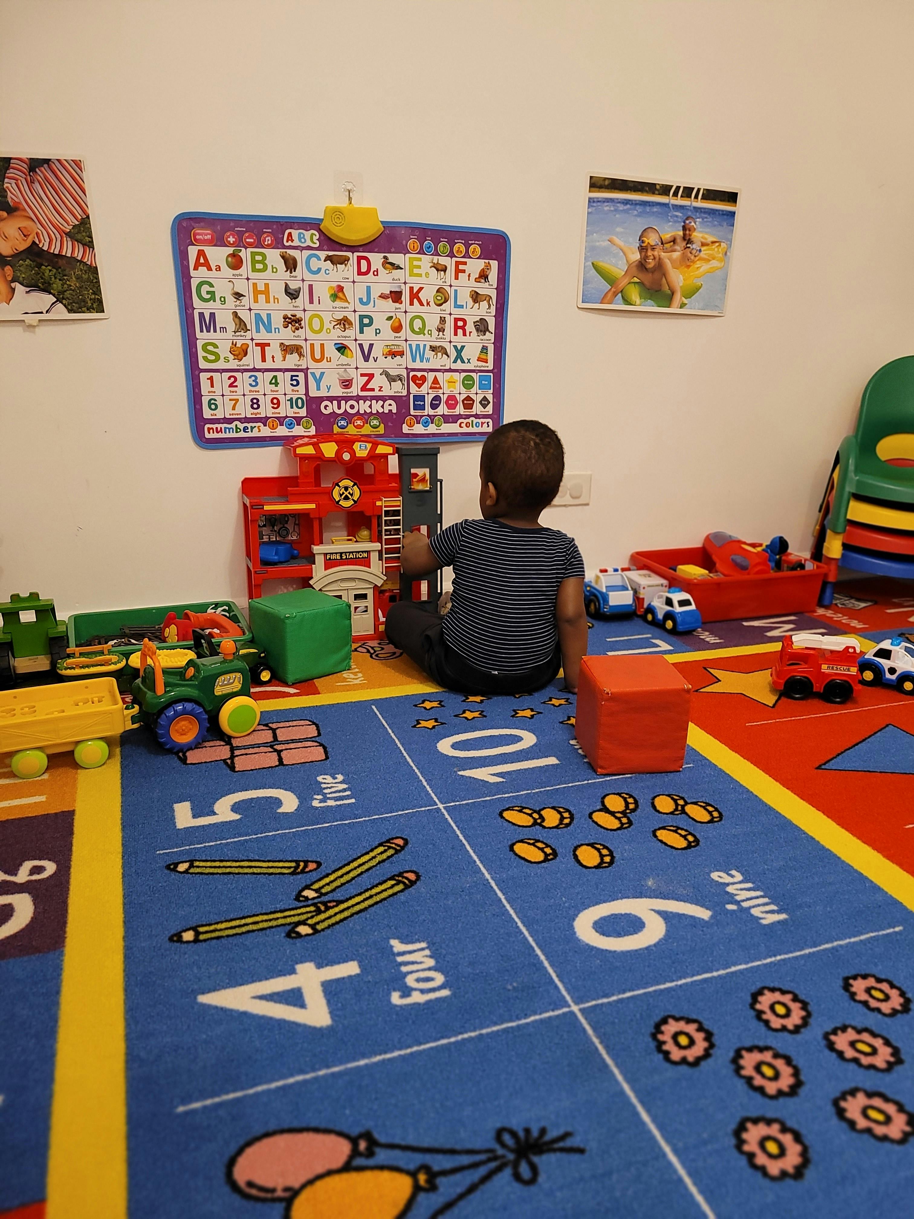 Child playing with toys on a colorful rug