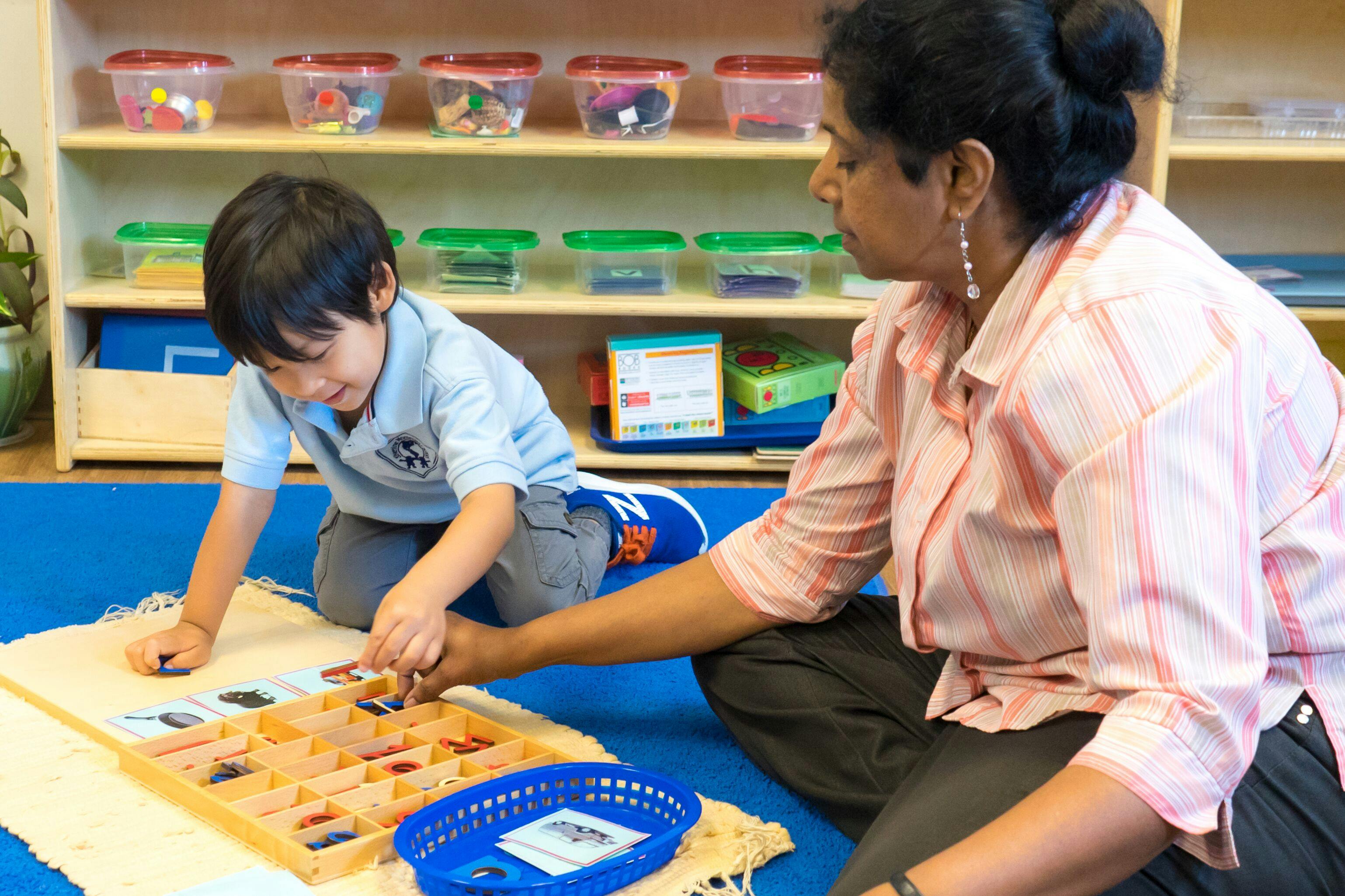 Adult and child on floor playing with learning materials