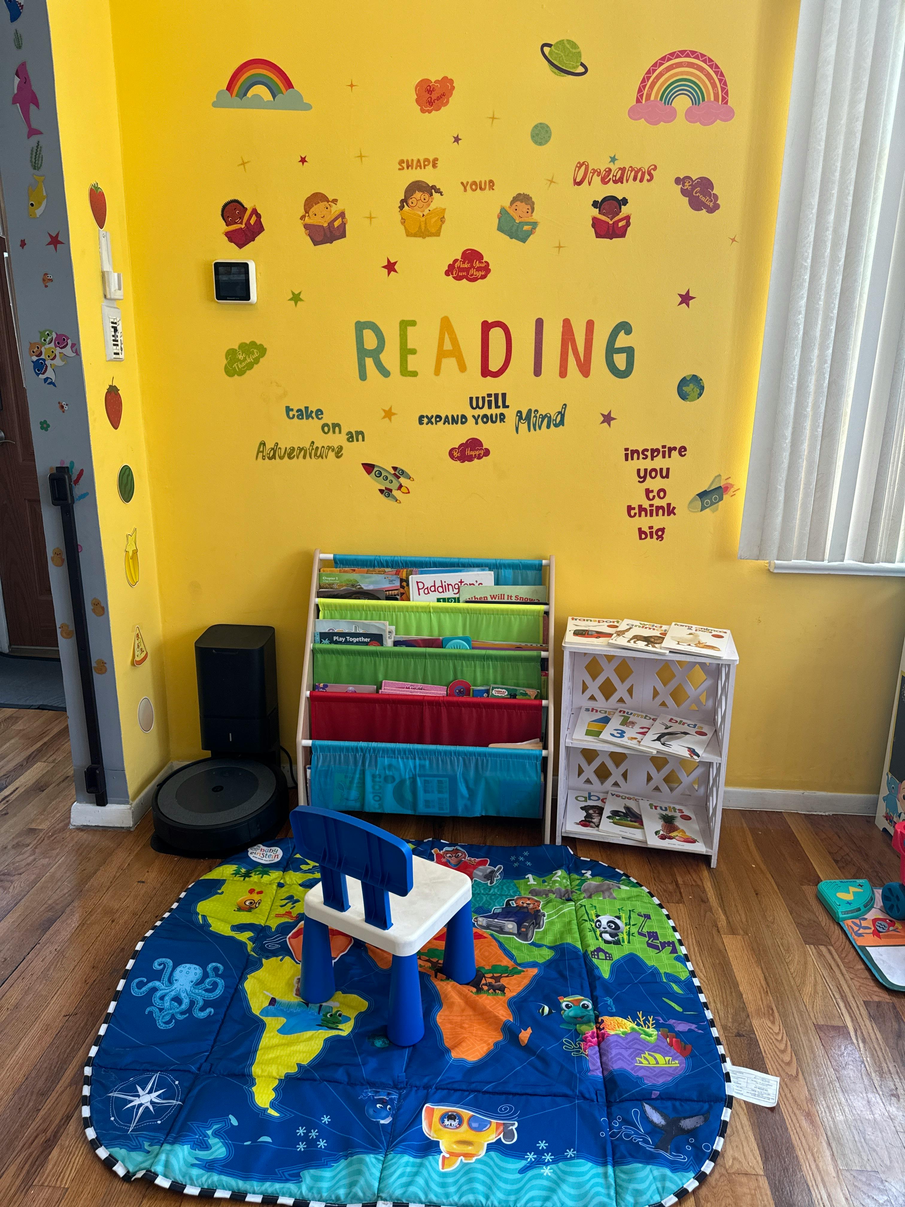 Children's reading nook with a world map rug, small chair, and bookshelves