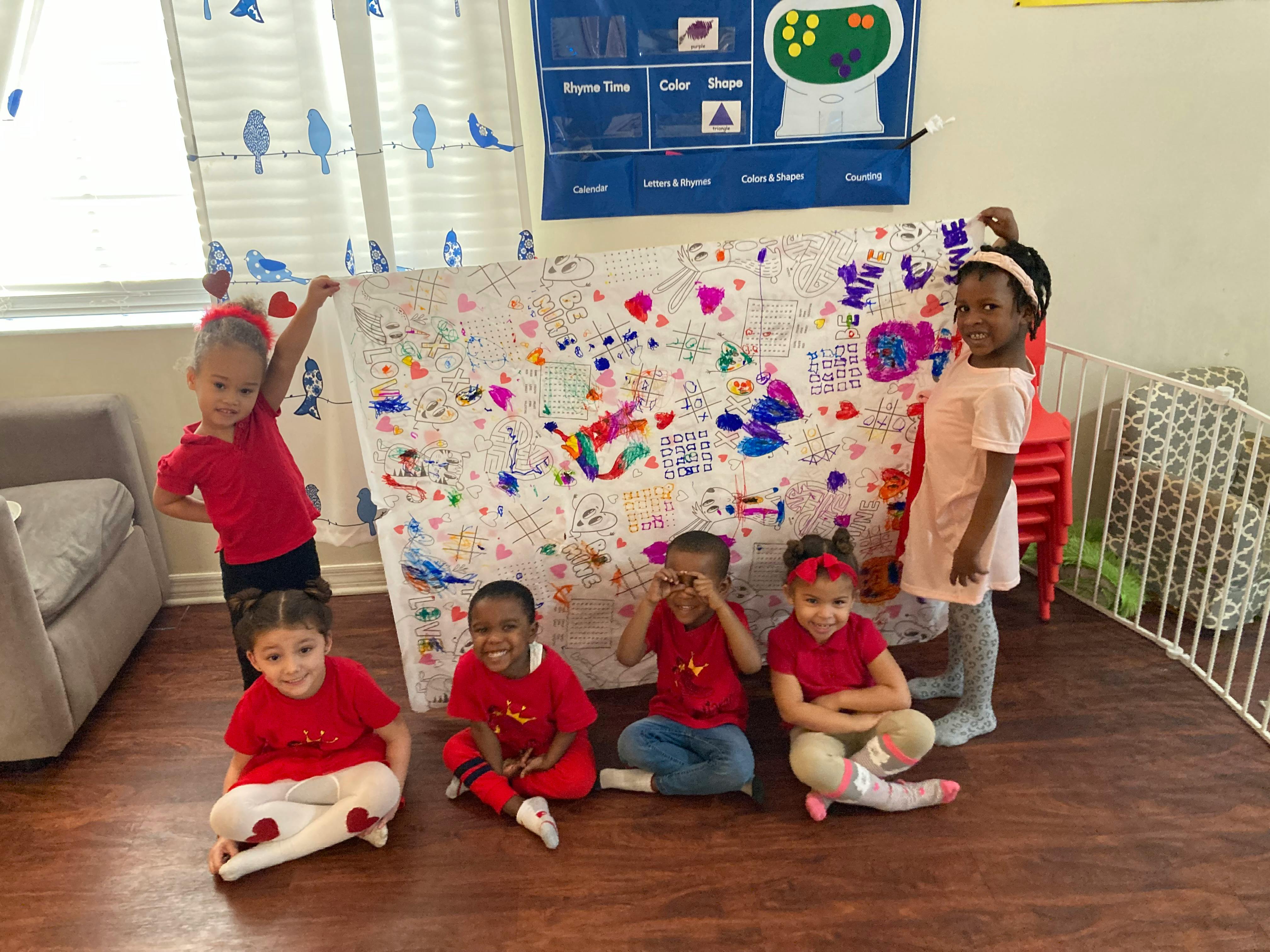 Group of children holding a large decorated poster in a classroom