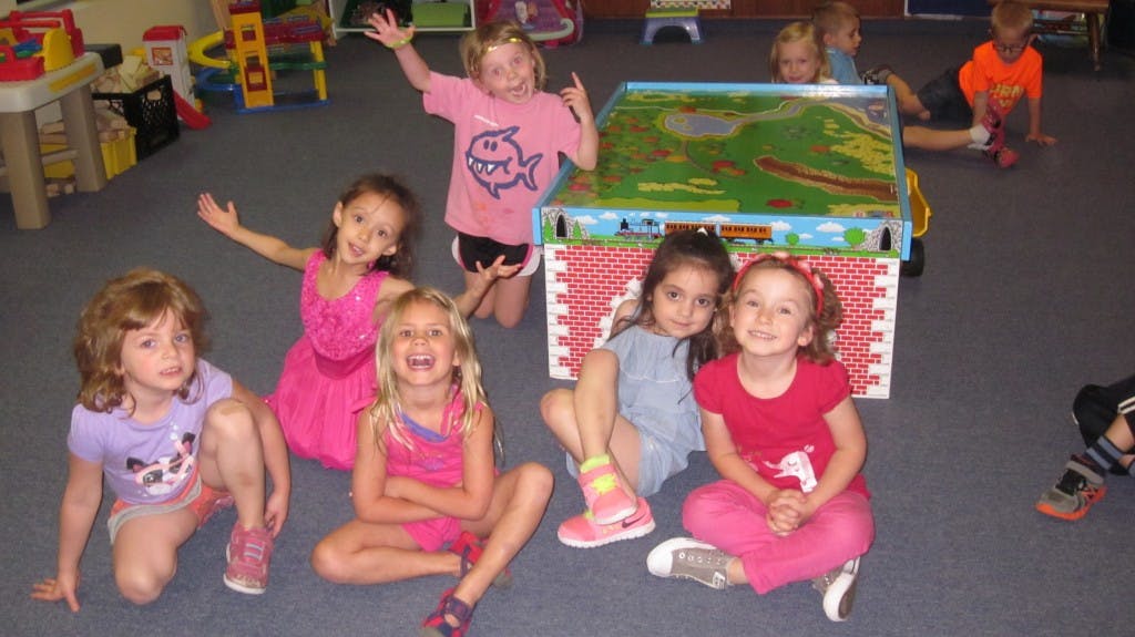 Group of children sitting and kneeling on a floor