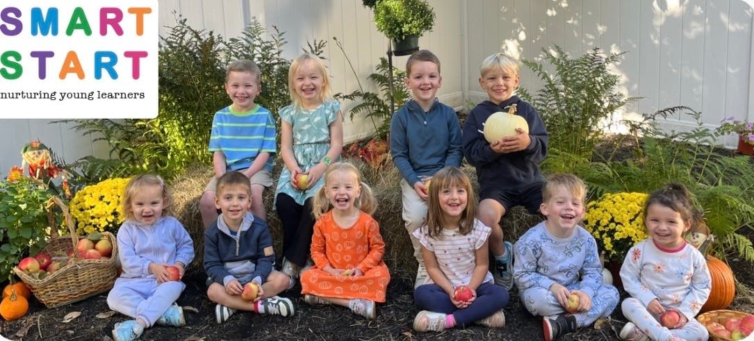 Group of children holding apples and a pumpkin, with a Smart Start logo