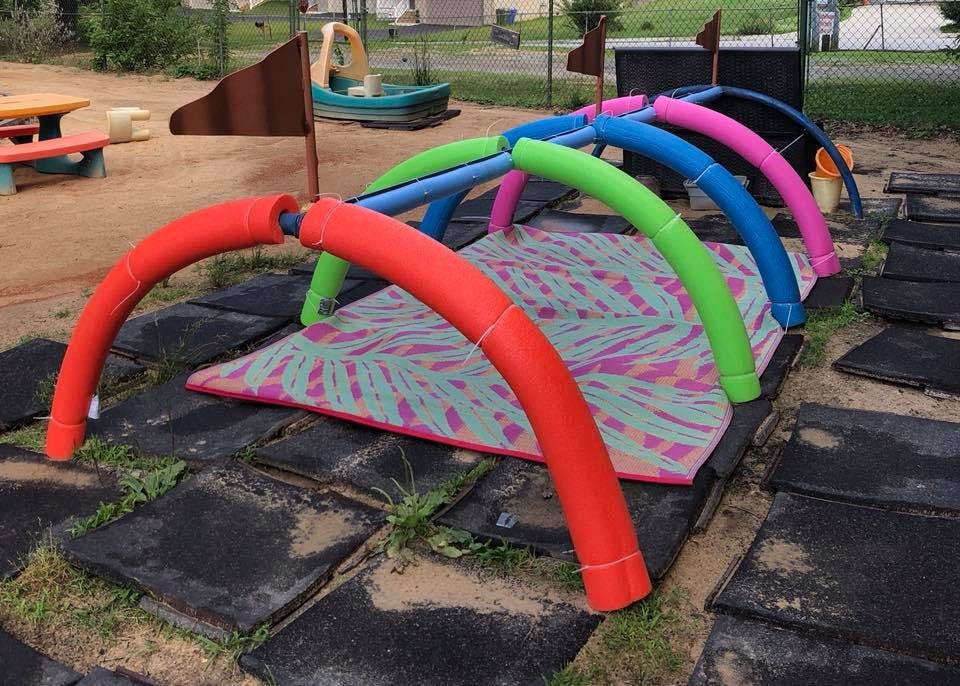 Colorful arched play tunnel over a patterned mat on a playground