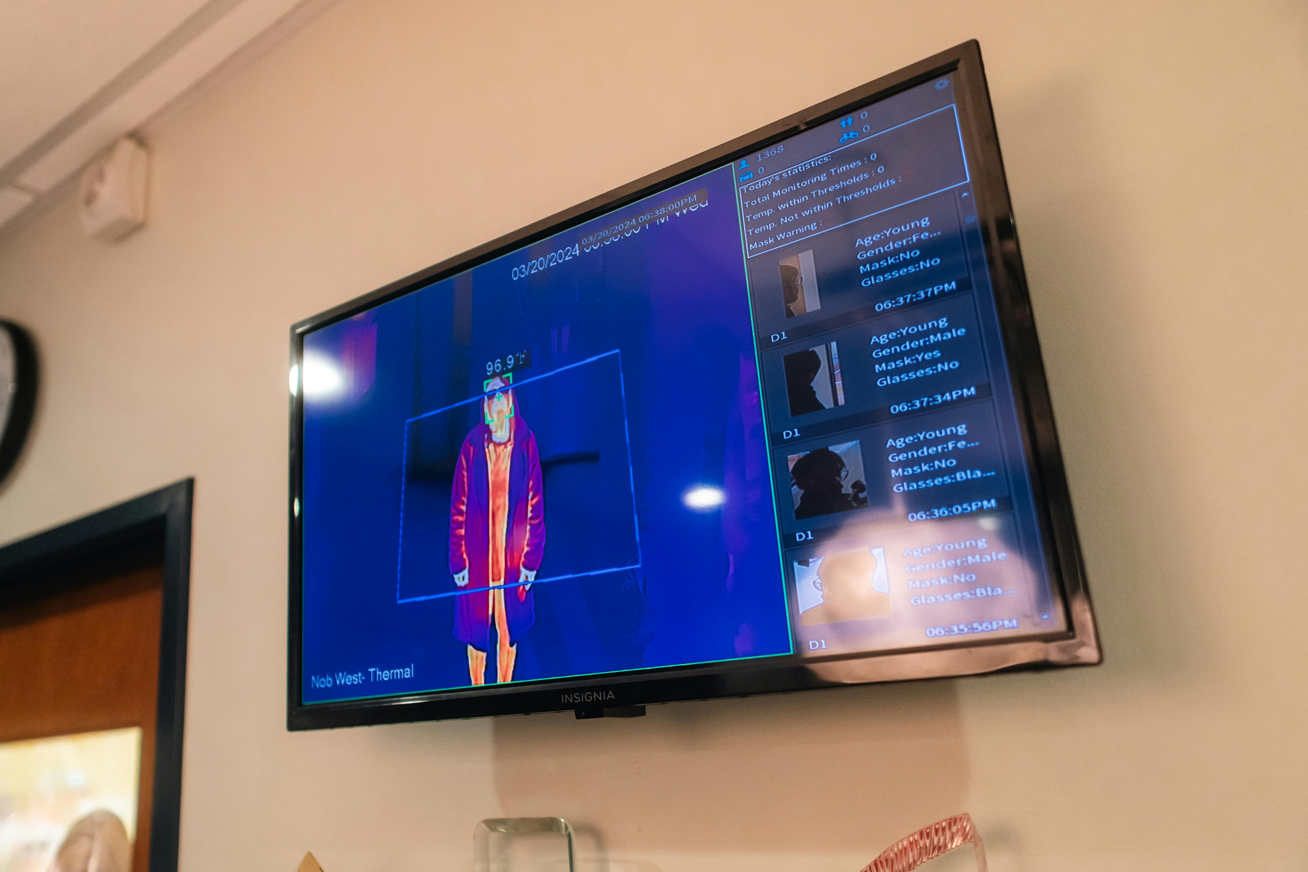 TV screen displaying thermal image of person and monitoring statistics